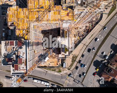 Le site de construction présente des matériaux et des équipements vibrants sous la lumière du soleil dans une zone urbaine. Vue aérienne de haut en bas Banque D'Images