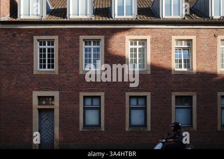 Un bâtiment classique en briques rouges avec des fenêtres symétriques encadrées en pierre. Banque D'Images