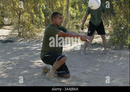 04 juillet 2004 ; Camp Fallujah, Irak ; Sgt. ADRIAN E. RON, chef des opérations de transport motorisé du I Marine Expeditionary Force Headquarters Group, et un natif du comté d'Orange, Calif., descend pour une bosse lors d'un tournoi de volleyball le 2 juillet 2004. Le tournoi était l'un des nombreux événements mis à la disposition des Marines et des marins pour célébrer le jour de l'indépendance. Banque D'Images