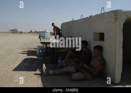 04 juil. 2004 ; Camp Fallujah, Irak ; équipe de drapeau-football Blue Falcons, Marines de la compagnie A, 1er bataillon, 5e régiment de Marines, prendre une pause à l'ombre comme ils attendent leur tour pour jouer dans le match de championnat contre la compagnie d'armes, 1er bataillon, 5e régiment de Marines au camp Fallujah, dimanche. Les Marines et les marins ont participé à d'autres tournois sportifs lors d'une célébration du jour de l'indépendance organisée par l'équipe de combat régimentaire 1 au centre de repos et de relaxation. Banque D'Images