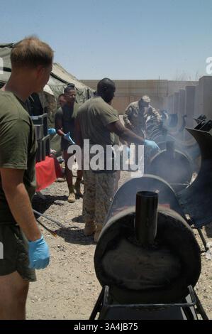 04 juillet 2004 ; Camp Fallujah, Irak ; Marines Man une rangée de grillades en préparation pour servir plus de 1 500 fêtards de l'équipe de combat régimentaire 1 pour leur fête du 4 juillet au Centre de repos et de relaxation au Camp Fallujah. Banque D'Images