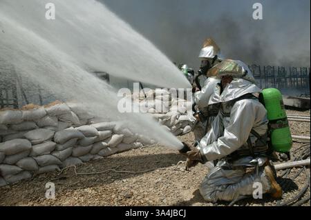 07 juillet 2004 ; Camp Al Asad, Irak ; les pompiers de la Marine et de l'Armée ont combattu un incendie pendant plus d'une heure dans la chaleur et à travers la fumée dans le Camp Al Asad, le 7 juillet. Les flammes étaient aussi proches que 10 pieds d'atteindre d'autres tentes. Un total de 141 Marines 3e bataillon, 4e régiment de Marines ont perdu tous leurs biens. Banque D'Images