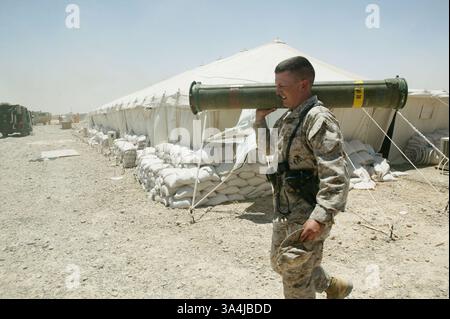 07 juillet 2004 ; Camp Al Asad, Irak ; le Major BRENT R. NORQUIST, officier logistique de l'équipe de combat régimentaire 7, récupère un missile dans une tente près d'un feu à proximité dans le Camp Al Asad, le 7 juillet. Les flammes étaient aussi proches que 10 pieds d'atteindre la tente. Banque D'Images