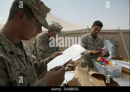 10 juillet 2004 ; Camp Al Asad, Irak ; le Cpl JOHN P. TREVINO, 22 ans, de Pharr, Texas, lit une lettre tirée d'un colis envoyé par des partisans de l'église de la communauté chrétienne New Hope à Vacaville, Calif. 10 juillet, au camp Al Asad. Banque D'Images