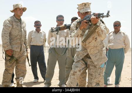 14 juillet 2004 ; Camp Al Asad, Irak ; 1er Sgt Octaviano GALLEGOS Jr., 37 ans, compagnie B, 3e Bataillon amphibien d'assaut, montre aux recrues de la police des frontières irakienne comment fouiller et saisir correctement un bâtiment, tandis que lance le caporal NICHOLAS G. BIBBY, 21 ans, un intrus de Los Angeles, l'explique étape par étape aux hommes irakiens le 14 juillet. Le cours, qui est le premier à l'Académie de police d'Al-Assad, est un cours de 10 jours qui leur permettra de patrouiller les frontières occidentales de l'Irak. Banque D'Images
