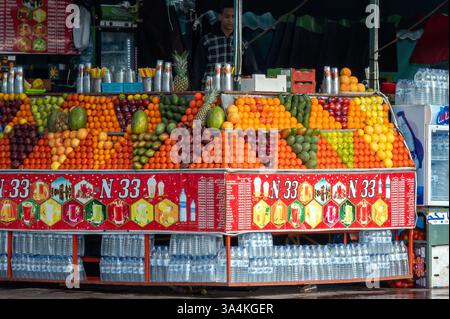 Marrakech, Maroc - 16 février 2025 : la disposition colorée des fruits attire les visiteurs à un étal de marché animé à Marrakech. Banque D'Images