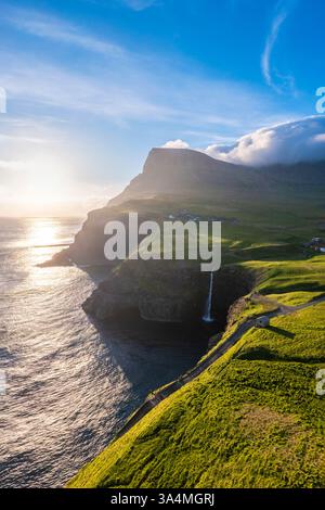 Vue aérienne de la cascade de Mulafossur avec le petit village de Gasadalur. Île de Vagar, Îles Féroé, Danemark, Europe. Banque D'Images