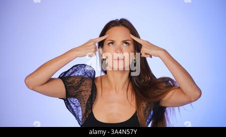 Femme pratiquant le yoga facial en appuyant sur le front Banque D'Images