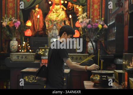 4 octobre 2014 - Hong Kong, CHN - Wat, un natif de Hong Kong âgé de 24 ans, bâtons d'encens légers au temple Tin Hau, sur Temple Street dans le district de Yau ma Tei de Kowloons le 4 octobre 2014 à Hong Kong. Le temple est populaire auprès des fidèles, même en période de protestation, avec la principale zone d'occupation de Mongkok à quelques pâtés de maisons. (Crédit image : © Chris Stowers/MCT/ZUMA Wire) Banque D'Images
