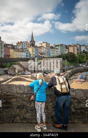 Couple prenant dans la vue sur le port de Tenby dans le sud du pays de Galles, Royaume-Uni. Banque D'Images