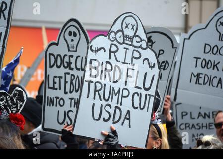 Manifestants avec de fausses pierres tombales lors d'un rassemblement Stop the Cuts contre DOGE dans Lower Manhattan. Banque D'Images