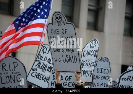 Manifestants avec de fausses pierres tombales lors d'un rassemblement Stop the Cuts contre DOGE dans Lower Manhattan. Banque D'Images