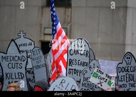 Manifestants avec de fausses pierres tombales lors d'un rassemblement Stop the Cuts contre DOGE dans Lower Manhattan. Banque D'Images