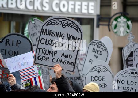 Manifestants avec de fausses pierres tombales lors d'un rassemblement Stop the Cuts contre DOGE dans Lower Manhattan. Banque D'Images