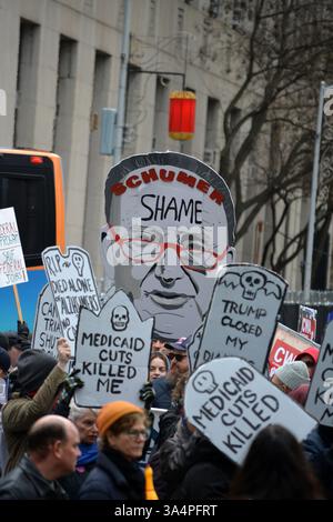 Manifestants avec de fausses pierres tombales lors d'un rassemblement Stop the Cuts contre DOGE dans Lower Manhattan. Banque D'Images