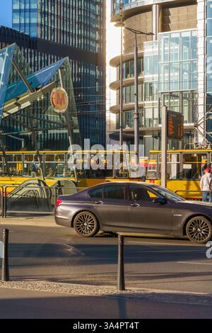 Varsovie, Pologne centre-ville d'affaires - Rondo ONZ dans les rayons dorés du soleil couchant du soir. Les gens attendent l'arrivée du prochain tram. Banque D'Images