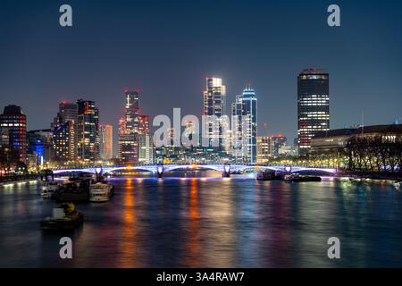 La ligne d'horizon animée de Vauxhall présente des gratte-ciels illuminés reflétant les eaux tranquilles de la Tamise pendant la nuit à Londres, mettant en valeur le charme moderne de la ville. Banque D'Images