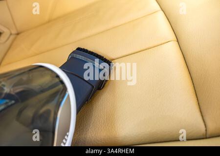 Petit aspirateur portatif alimenté par batterie, nettoyage des ordures à l'intérieur de la voiture, rénovation de sièges d'auto beiges Banque D'Images