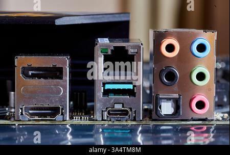 Gros plan détaillé d'une carte mère d'ordinateur, présentant divers ports, y compris Ethernet, USB, HDMI et connexions audio. Idéal pour illustrer t Banque D'Images