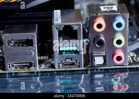 Gros plan détaillé d'une carte mère d'ordinateur, présentant divers ports, y compris Ethernet, USB, HDMI et connexions audio. Idéal pour illustrer t Banque D'Images