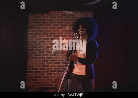 Musicien exécutant passionnément sur scène avec microphone vintage, profiter du moment, copier l'espace Banque D'Images