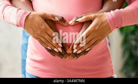 Mains de la femme et du mari sur le ventre de la femme enceinte Banque D'Images