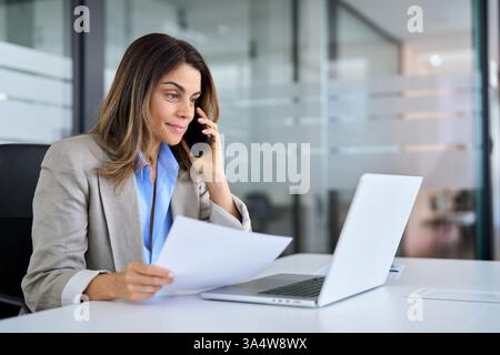Cadre de femme professionnelle d'âge moyen faisant un appel parlant au téléphone au travail. Banque D'Images