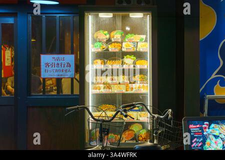 Osaka, Japon - 21 septembre 2024, Une vue rapprochée de la vitrine vitrée d'un restaurant avec des modèles de cire de la cuisine japonaise, avec un vélo garé à Forward Banque D'Images
