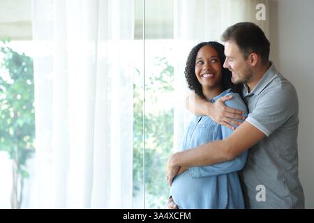 Heureuse femme enceinte noire regardant son mari à la maison Banque D'Images