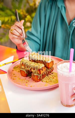 Pain grillé à la cannelle avec garniture à la pistache servi avec milk-shake dans un café-restaurant chic. Banque D'Images