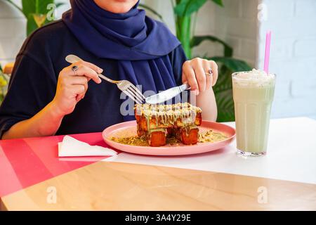 Pain grillé à la cannelle avec garniture à la pistache servi avec milk-shake dans un café-restaurant chic. Banque D'Images