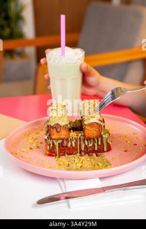 Pain grillé à la cannelle avec garniture à la pistache servi avec milk-shake dans un café-restaurant chic. Banque D'Images