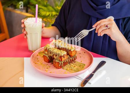 Pain grillé à la cannelle avec garniture à la pistache servi avec milk-shake dans un café-restaurant chic. Banque D'Images
