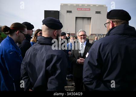 Le premier ministre Sir Keir Starmer parle aux sous-mariniers de la Royal Navy du sous-marin nucléaire HMS Agamemnon et aux apprentis du système BAE à l'extérieur de l'usine BAE System, Barrow-in-Furness, Cumbria, au nord-ouest de l'Angleterre. Date de la photo : jeudi 20 mars 2025. Banque D'Images
