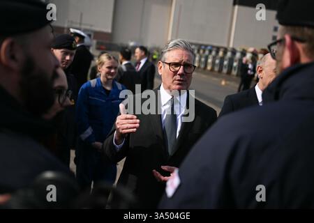 Le premier ministre Sir Keir Starmer parle aux sous-mariniers de la Royal Navy du sous-marin nucléaire HMS Agamemnon et aux apprentis du système BAE à l'extérieur de l'usine BAE System, Barrow-in-Furness, Cumbria, au nord-ouest de l'Angleterre. Date de la photo : jeudi 20 mars 2025. Banque D'Images