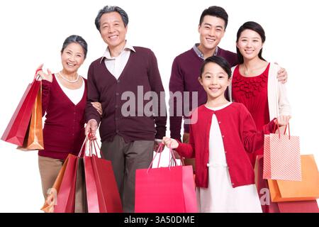 Heureuse famille chinoise avec des sacs à provisions célébrant ensemble. Parfait pour les campagnes festives, les moments en famille et les thèmes de shopping des fêtes, y compris le nouvel an chinois et les réunions de famille. Idéal pour le commerce électronique et le contenu de vente au détail destiné aux publics d'Asie de l'est. Banque D'Images