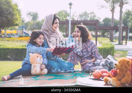Maman et ses filles passent du temps ensemble au parc de Dubaï. Un moment chaleureux en famille capturé en plein air, idéal pour les parents, le style de vie et les thèmes de voyage aux Émirats arabes Unis. Banque D'Images