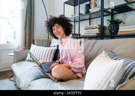 Belle latino jeune femme à la maison - joli sud-américain avec des cheveux bouclés portrait de femme, style de vie et scène de vie domestique Banque D'Images