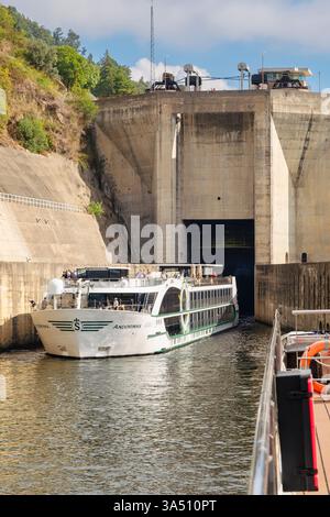 Bateau de croisière fluviale quittant l'écluse de Carrapatelo dans un barrage sur le fleuve Douro, Portugal, Europe. Banque D'Images