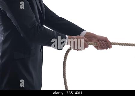 Gros plan d'un homme d'affaires du moyen-Orient tirant une corde, symbolisant les liens et la pression dans un contexte d'entreprise. L'image est isolée sur un fond de studio blanc, adapté aux thèmes de concept d'entreprise et de carrière. Banque D'Images