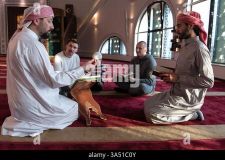Groupe de musulmans dans une mosquée lisant le Coran ensemble, soulignant l'éducation islamique et le culte. Convient pour les programmes fondés sur la foi, l'éducation religieuse et la sensibilisation communautaire. Une scène calme et respectueuse idéale pour le marketing culturel et religieux. Banque D'Images