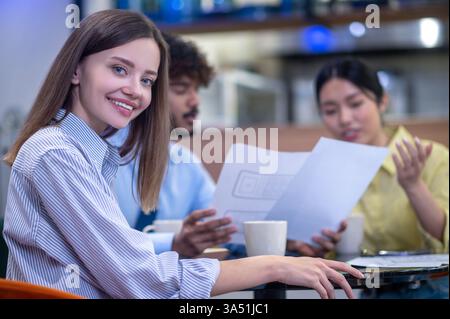 Groupe diversifié de collègues collaborant à un projet, ayant l'air engagés et impliqués. Cette image est idéale pour le travail d'équipe, la collaboration professionnelle et la planification des moments sur le lieu de travail. Banque D'Images