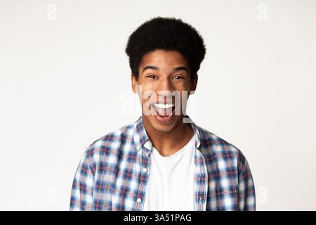 Homme excité exprimant la surprise sur un fond de studio lumineux. portrait expressif adapté pour la publicité, les prises de vue de réaction et les campagnes de divertissement. Banque D'Images