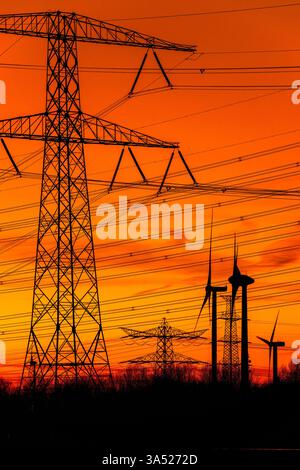 Pylônes électriques haute tension / tours de transmission et éoliennes au coucher du soleil près de la centrale nucléaire de Borssele, Zélande, pays-Bas Banque D'Images