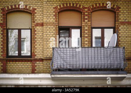 La façade d'un ancien immeuble résidentiel avec une façade en briques de clinker et un balcon nostalgique Banque D'Images