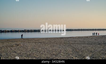 La plage de Marina di Ravenna en fin d'après-midi de l'hiver avec les blocs lourds horizontaux barrière contre l'érosion de la plage dans la mer Adriatique. Ravenna p Banque D'Images