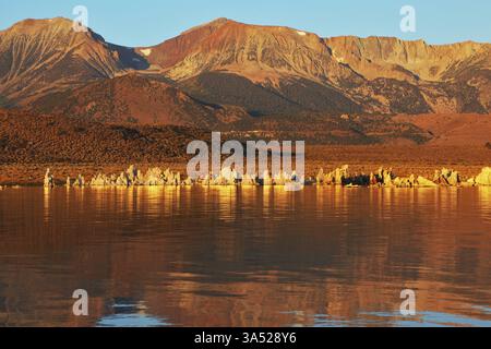 Coucher de soleil orange flamboyant sur le lac Mono. Aberrations - formation bizarre de tuf calcaire calcaire reflétée dans l'eau lisse Banque D'Images