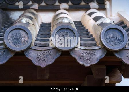 Himeji, Japon - 24 septembre 2024, vue rapprochée d'un toit en tuiles avec onigawara rond avec des motifs floraux, au temple Himeji, temple du Héron Blanc, à dayti Banque D'Images