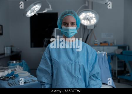 Chirurgien en salle d'opération portant des gommages et un masque, se préparant à la chirurgie Banque D'Images