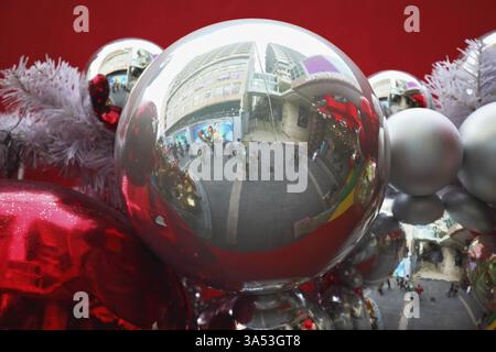 Magnifique guirlande de jouets d'arbre à fourrure. Sphères de verre rouge vif et argent sur fond rouge. Joyeux Noël ! Banque D'Images